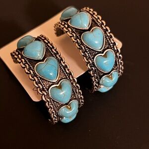 Stunning pierced Turquoise earrings with a dark metal hoop.